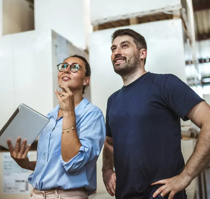 Logistics coordinators reviewing inventory together inside a distribution warehouse