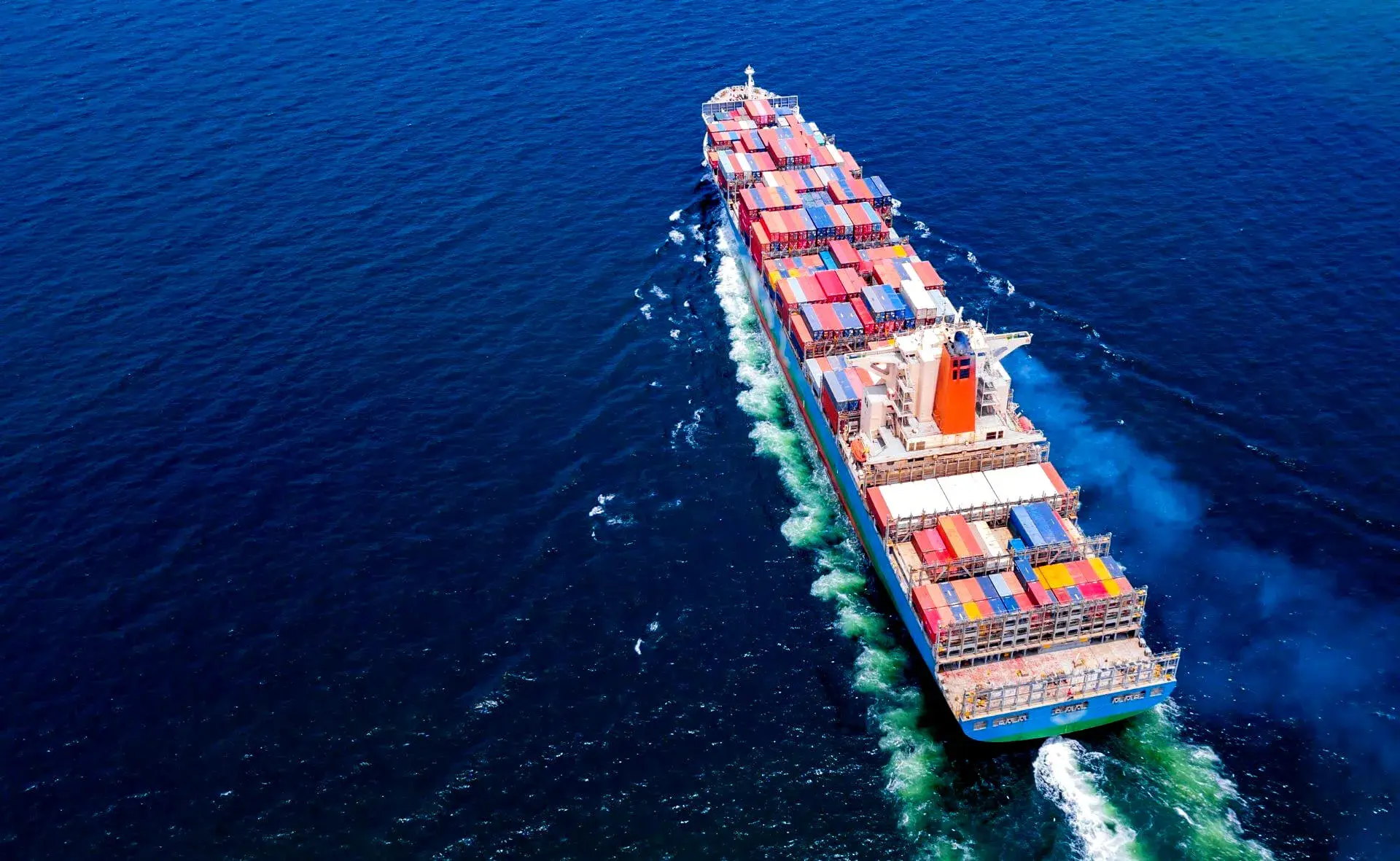 Aerial view of a loaded container ship crossing deep blue open water