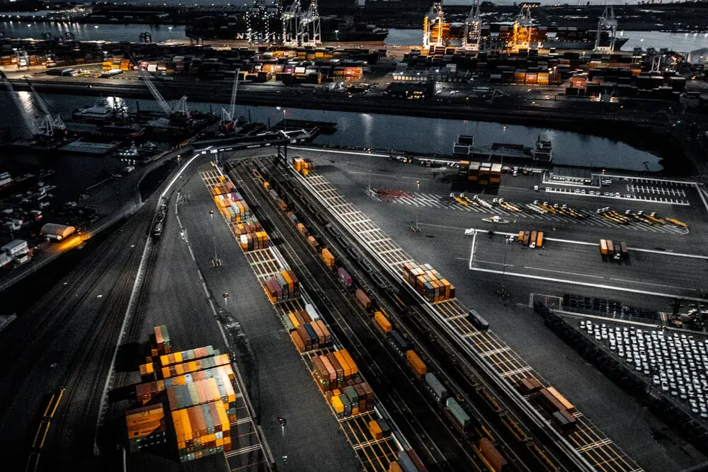 Aerial view of a container terminal and rail yard illuminated at night